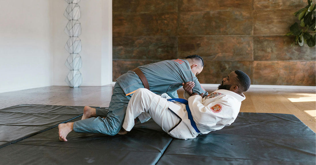 An image showing experienced BJJ black belts coaching white belt beginners on the mat, with key advice tips like “focus on basics” and “consistency is key” highlighted around them.